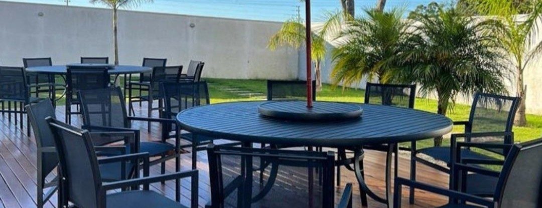 Mesa, cadeiras e ombrelone de área de lazer