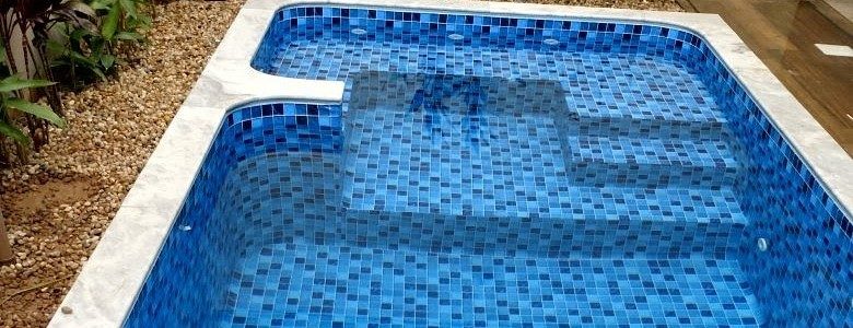Pastilha em mosaico azul revestindo borda de piscina
