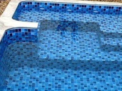 Pastilha em mosaico azul revestindo degrau de piscina